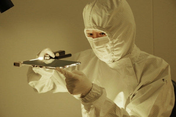 An SKC employee checks a mask blank prototype.